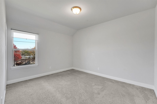 spare room with carpet floors and lofted ceiling