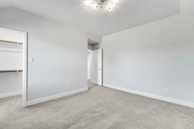 unfurnished bedroom featuring light colored carpet, a closet, and a spacious closet