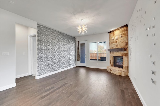 unfurnished living room with dark hardwood / wood-style flooring, a fireplace, and a chandelier