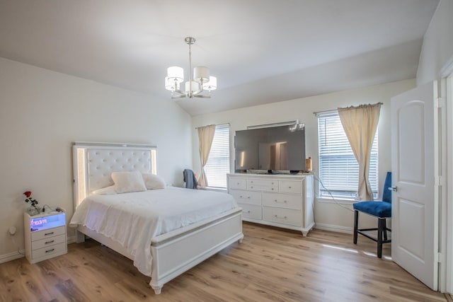 bedroom with light hardwood / wood-style flooring, an inviting chandelier, and lofted ceiling