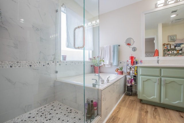 bathroom featuring hardwood / wood-style flooring, plus walk in shower, and vanity