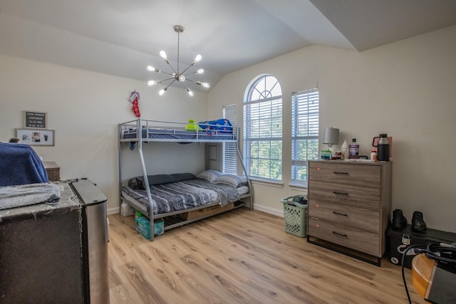 bedroom with vaulted ceiling, a notable chandelier, and light hardwood / wood-style flooring