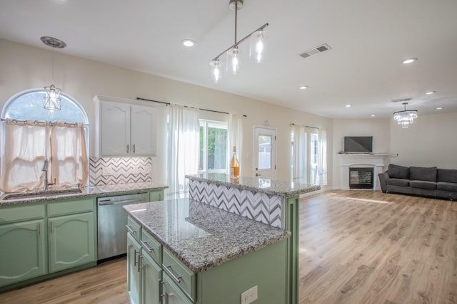 kitchen featuring green cabinetry, decorative light fixtures, and dishwasher