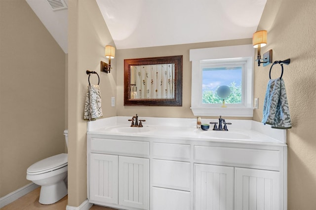 bathroom featuring tile patterned flooring, vanity, and toilet