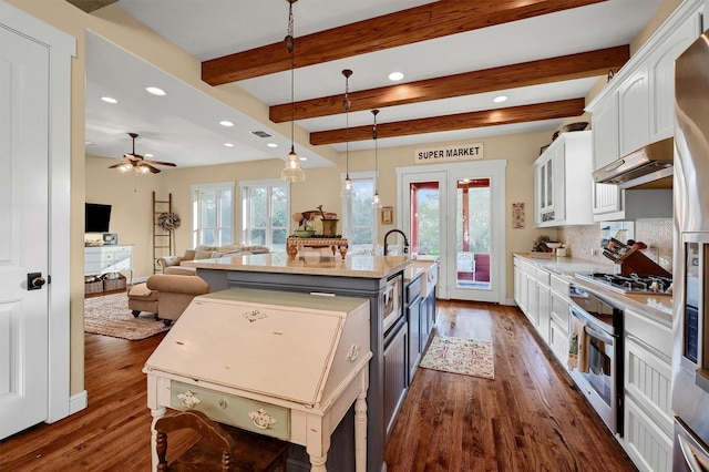 kitchen featuring a kitchen island with sink, appliances with stainless steel finishes, ceiling fan, pendant lighting, and white cabinets