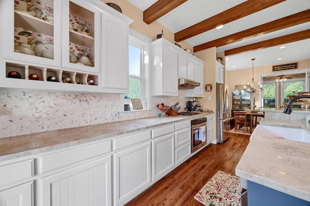 kitchen featuring backsplash, stainless steel appliances, white cabinets, and hanging light fixtures