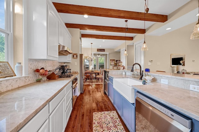 kitchen with appliances with stainless steel finishes, hanging light fixtures, beam ceiling, white cabinets, and sink