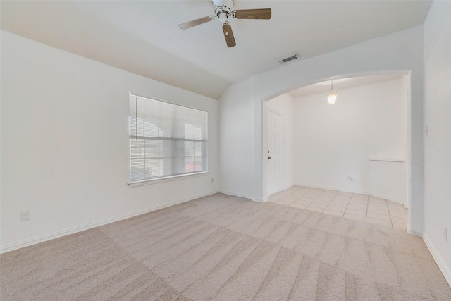 empty room with lofted ceiling, light carpet, and ceiling fan