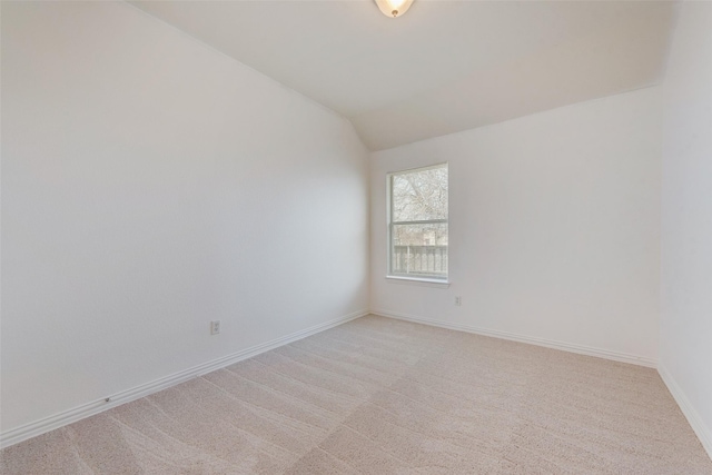 carpeted empty room with lofted ceiling