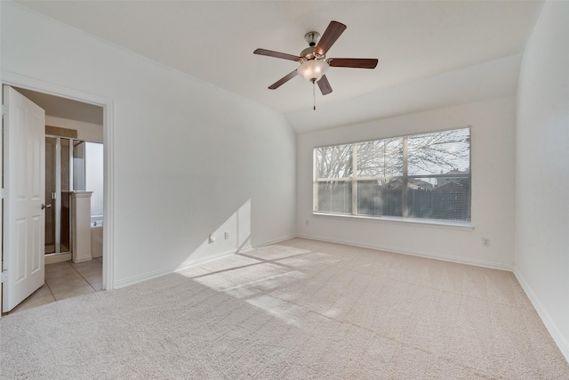 empty room featuring lofted ceiling, light colored carpet, and ceiling fan