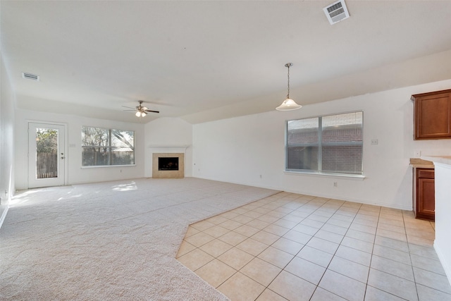 unfurnished living room with vaulted ceiling, ceiling fan, and light tile patterned floors