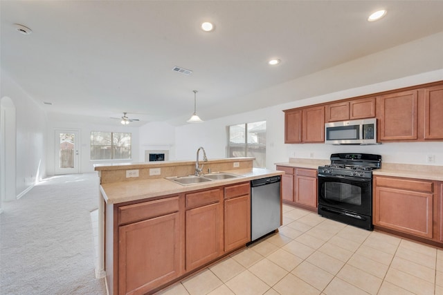 kitchen featuring sink, appliances with stainless steel finishes, ceiling fan, hanging light fixtures, and light colored carpet