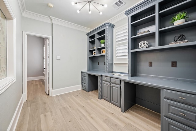 home office featuring crown molding, light hardwood / wood-style flooring, a wealth of natural light, and built in desk