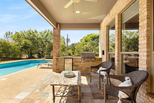 view of patio / terrace featuring a fenced in pool, exterior kitchen, and area for grilling