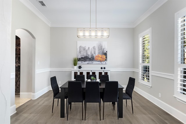 dining space with wood-type flooring and ornamental molding