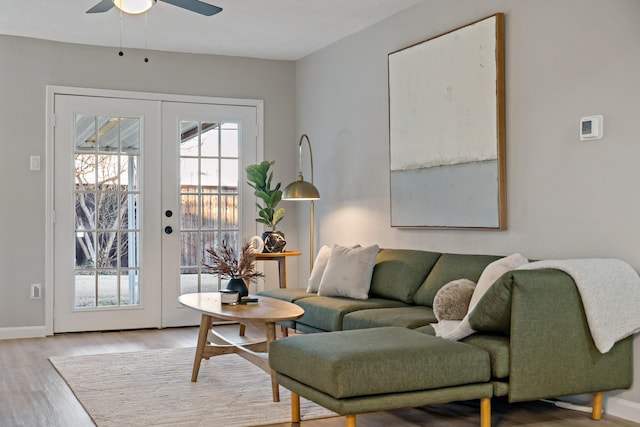 living room with ceiling fan, light hardwood / wood-style floors, and french doors