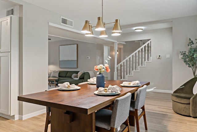 dining room featuring a notable chandelier and light hardwood / wood-style flooring