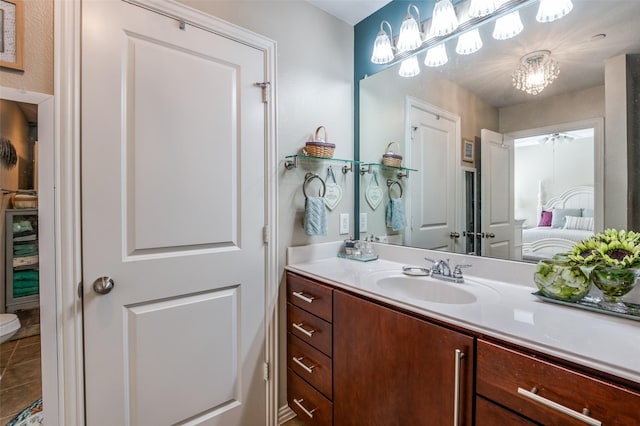 bathroom featuring an inviting chandelier, tile patterned floors, and vanity