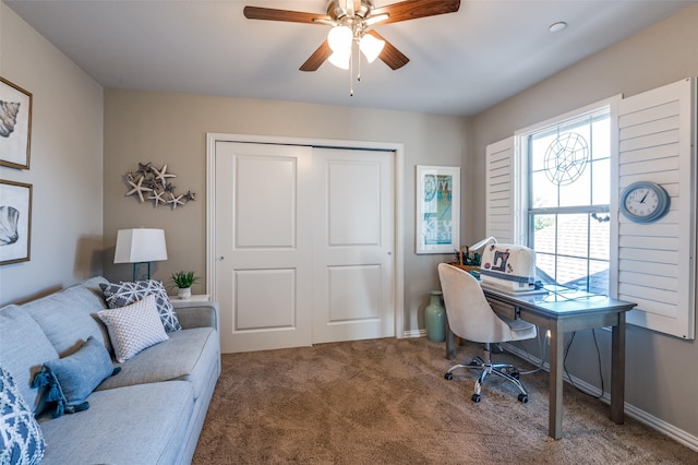 carpeted office space featuring ceiling fan