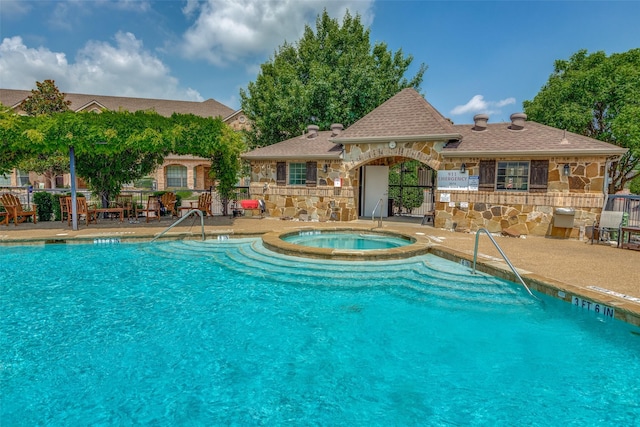 view of swimming pool with a hot tub and a patio