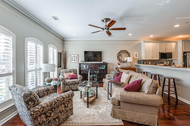 living room with ceiling fan, ornamental molding, dark hardwood / wood-style flooring, and plenty of natural light