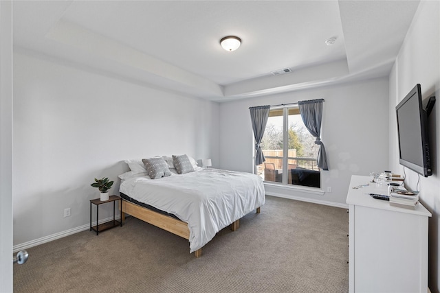 bedroom featuring carpet floors and a tray ceiling