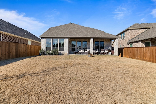 back of property featuring a yard and a patio