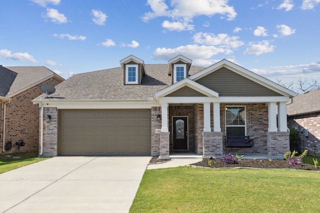 view of front of property featuring a front yard, a garage, and a porch