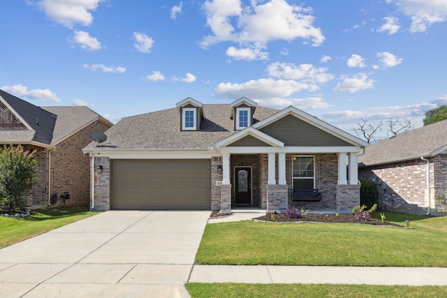 craftsman house with covered porch, a front yard, and a garage