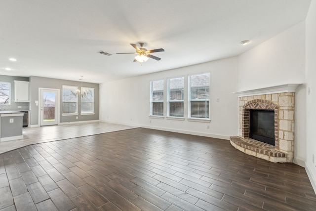 unfurnished living room featuring ceiling fan with notable chandelier