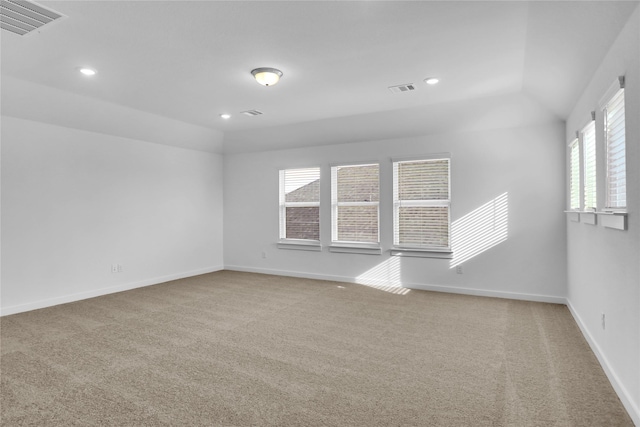 carpeted empty room with vaulted ceiling