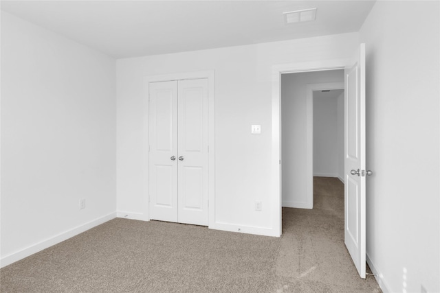 unfurnished bedroom with a closet and light carpet