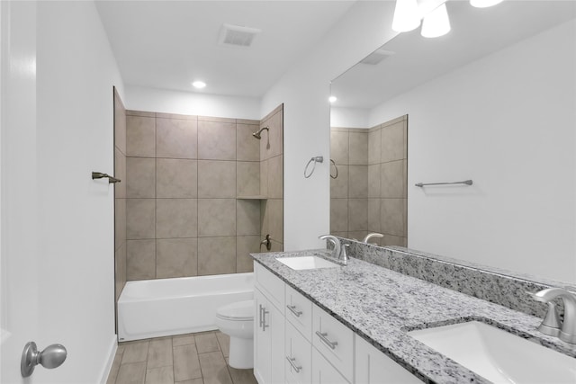 full bathroom with toilet, vanity, and tiled shower / bath