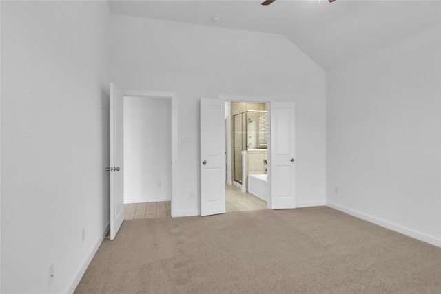 unfurnished bedroom featuring lofted ceiling, connected bathroom, light carpet, and ceiling fan