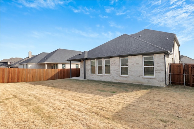 back of house with a lawn