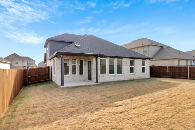 rear view of house with a patio and a yard