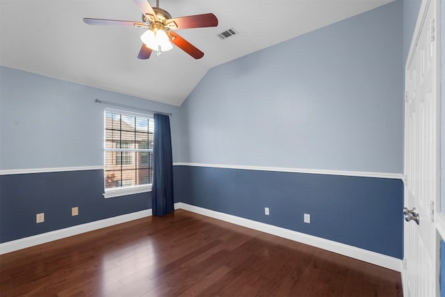 empty room with lofted ceiling, dark hardwood / wood-style flooring, and ceiling fan