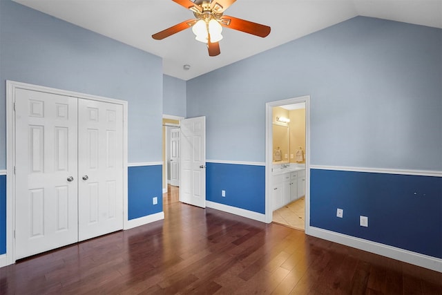 unfurnished bedroom featuring vaulted ceiling, ensuite bathroom, a closet, ceiling fan, and wood-type flooring