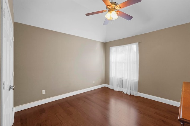 empty room featuring ceiling fan, vaulted ceiling, and dark wood-type flooring