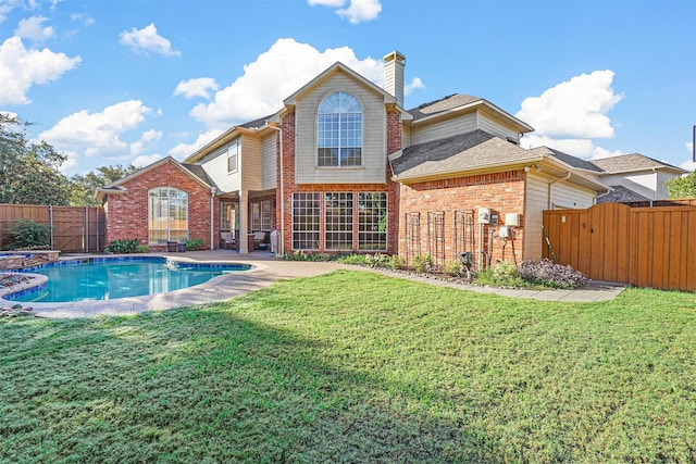 rear view of property with a patio area, a lawn, and a fenced in pool