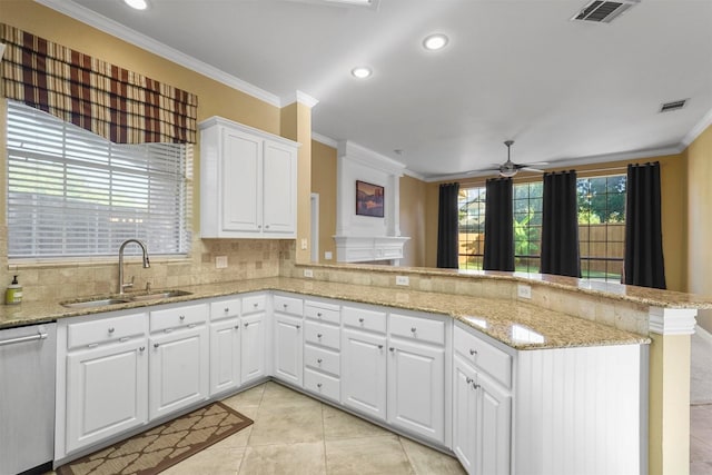 kitchen with dishwasher, kitchen peninsula, light tile patterned floors, sink, and white cabinetry