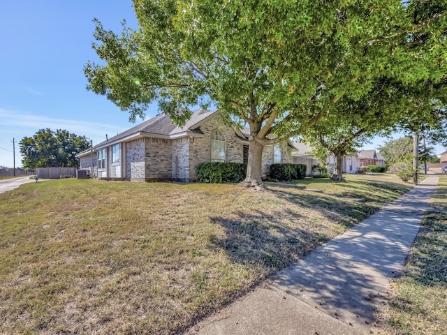 ranch-style home with central air condition unit and a front lawn