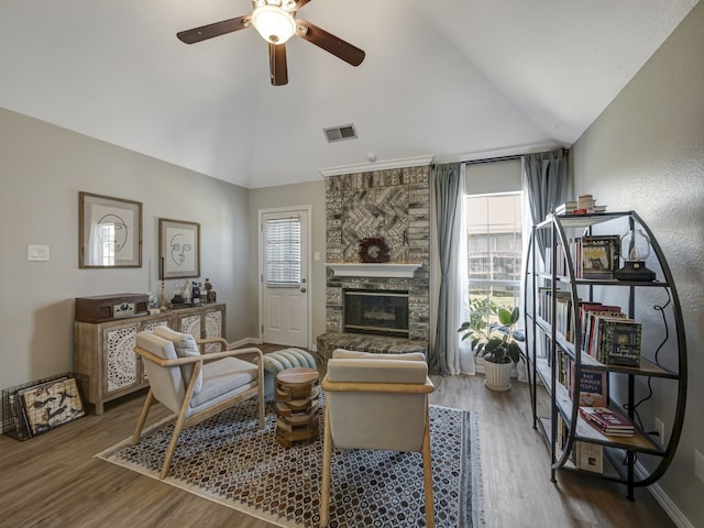 living room featuring lofted ceiling, a fireplace, a healthy amount of sunlight, and dark hardwood / wood-style floors