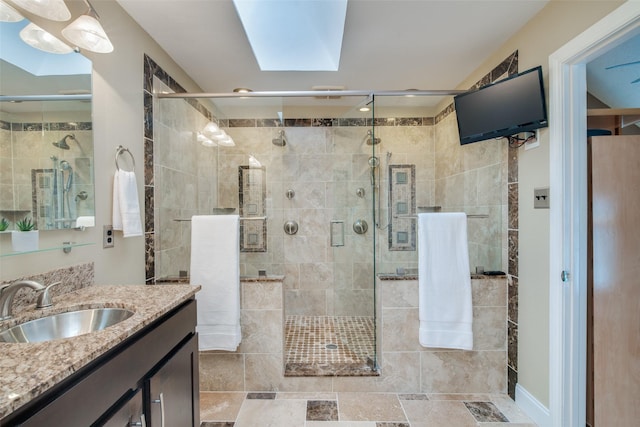 bathroom featuring vanity, a skylight, and walk in shower