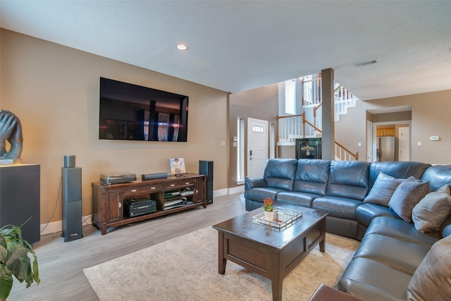 living room featuring a textured ceiling and light hardwood / wood-style flooring