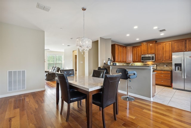 dining area featuring light wood-type flooring and a chandelier