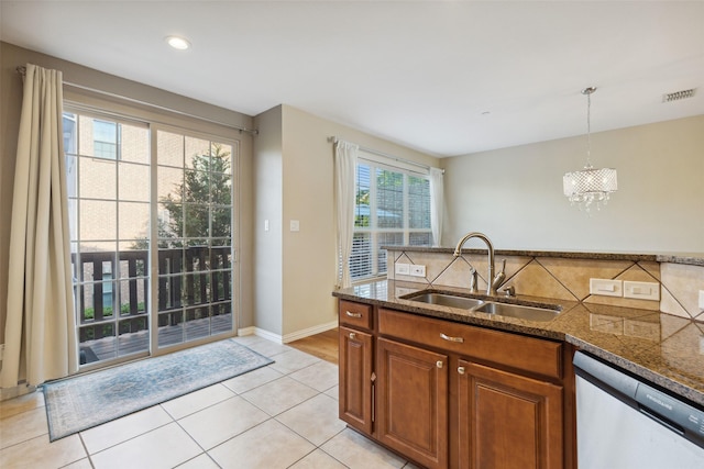 kitchen featuring sink, decorative light fixtures, stainless steel dishwasher, and light tile patterned floors