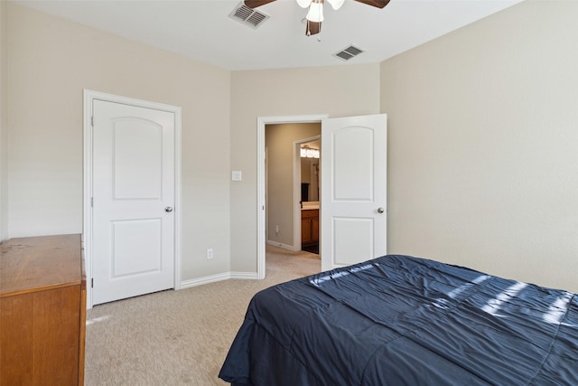 carpeted bedroom with ensuite bath and ceiling fan