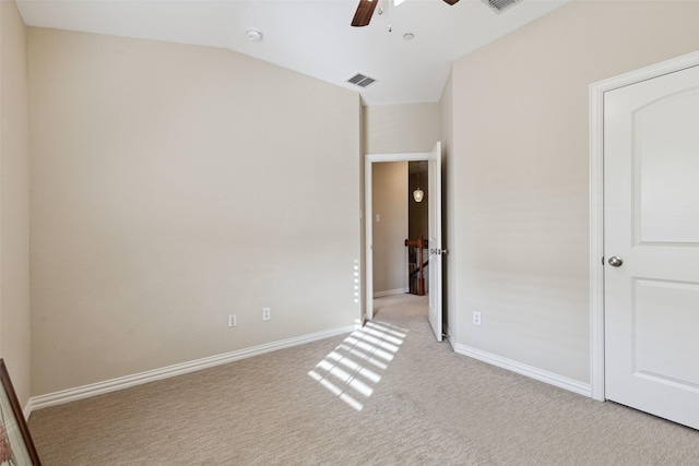 unfurnished bedroom with ceiling fan, vaulted ceiling, and light carpet