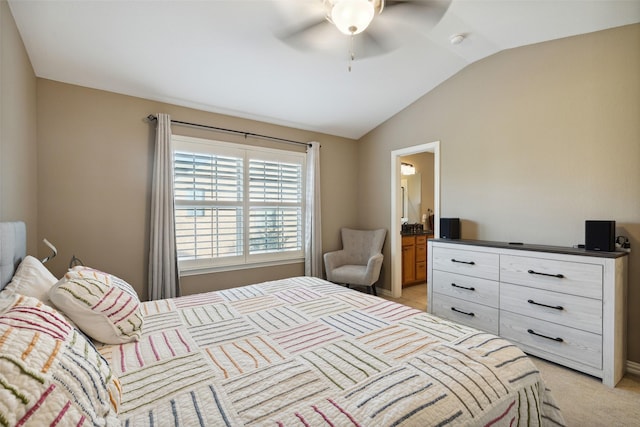 bedroom with ceiling fan, light colored carpet, ensuite bathroom, and vaulted ceiling